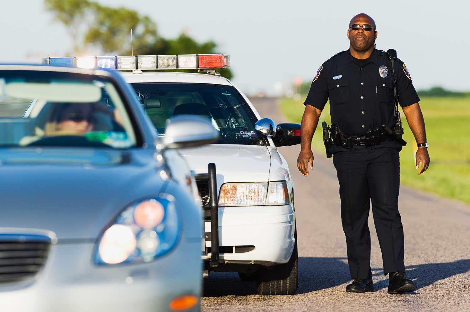 Police officer walking towards a convertible car